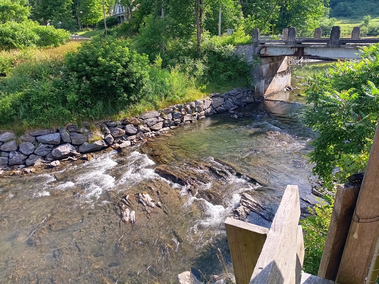 The Winooski River running past the stone bank below the bridge
